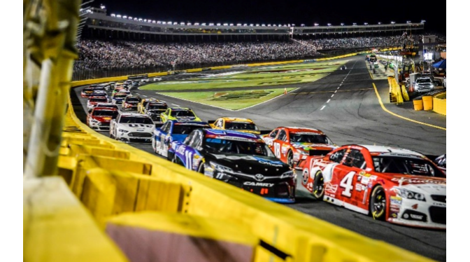 Photograph of race cars and grandstands at Charlotte Motor Speedway illustrating tourism and hospitality.