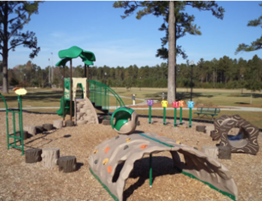 Photograph of a children's playground structure on a wood-chip surface.